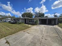 Single-story home with attached carport and large driveway at 318 Pearl Ave, Sarasota, FL 34243