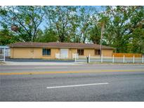 Single-story home with white picket fence and paved driveway at 703 W Sligh Ave, Tampa, FL 33604