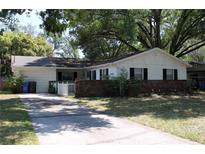 Charming single-story home with a brick accent wall and a driveway leading to a one-car garage at 7116 Kingsbury Cir, Tampa, FL 33610