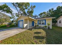 Updated bungalow with a freshly painted exterior, new landscaping, and a bright blue garage door at 7471 35Th N St, Pinellas Park, FL 33781