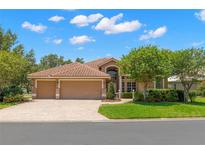 Beautifully landscaped home with a three-car garage and a red tile roof at 1160 Darlington Oak Ne Dr, St Petersburg, FL 33703