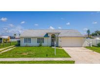 Charming single-story home with a welcoming front yard and attached garage at 13346 Carter Ave, Port Charlotte, FL 33981