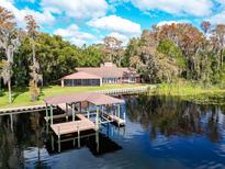 Beautiful lakefront home featuring a private dock and lush green surroundings at 18120 Wayne Rd, Odessa, FL 33556