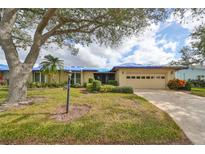 One-story home with attached garage, landscaping, and covered entryway at 2701 Lancaster Dr, Sun City Center, FL 33573