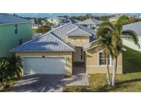 Single-Gathering house exterior with metal roof and two palm trees at 442 Bahama Grande Blvd, Apollo Beach, FL 33572