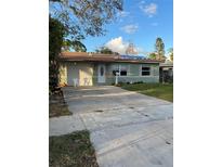 Ranch-style house with a green exterior, driveway, and lawn at 1787 Shore Acres Ne Blvd, St Petersburg, FL 33703