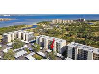 Scenic aerial view of condo complex with lush landscaping and waterfront views and covered parking at 2700 Cove Cay Dr # 2F, Clearwater, FL 33760
