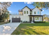 Stunning two-story home with balcony, large windows, well manicured lawn, and attached two car garage at 6303 Barton Rd, Plant City, FL 33565