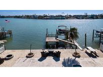 Private waterfront dock with boat lift and seating area at 807 Bay Point Dr, Madeira Beach, FL 33708