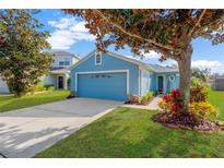 Charming blue home with attached garage and landscaped front yard at 10641 Navigation Dr, Riverview, FL 33579