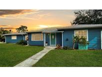 Charming single-story home featuring a well-manicured lawn and a vibrant, freshly-painted exterior at 1714 58Th S St, Gulfport, FL 33707