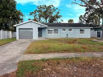 Light blue single story home with a gray garage door and a small front yard at 1817 Oregon Ne Ave, St Petersburg, FL 33703