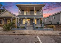 Two-story house with wrap-around porch and gray siding at 1910 E Columbus Dr, Tampa, FL 33605