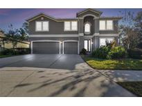 Two-story house with three-car garage and landscaped yard at 2212 Valterra Vista Way, Valrico, FL 33594