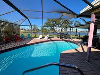Relaxing pool area with screened enclosure, offering water views at 2765 Mauritania Rd, Punta Gorda, FL 33983