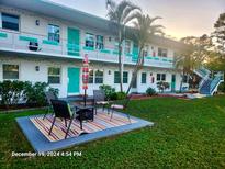 Two-story building with teal accents, patio furniture, and landscaped lawn at 6100 21St N St # 20, St Petersburg, FL 33714