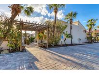 Inviting entryway with pergola, bench, and lush landscaping at 4621 Gulf Of Mexico Dr # D10, Longboat Key, FL 34228