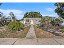Gray house with yellow door, landscaped yard, and walkway at 4809 11Th S Ave, St Petersburg, FL 33711