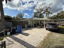 Ranch style home with carport and small front yard at 10002 Memorial Hwy, Tampa, FL 33615