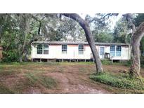 Mobile home exterior with mature trees. Needs renovation at 12403 Banbury Ave, New Port Richey, FL 34654