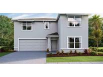 Two-story home with gray siding, two-car garage, and landscaping at 1288 Maritime Hammock Ave, Ruskin, FL 33570