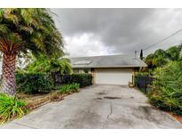 House exterior featuring a driveway, garage, and well-manicured landscaping at 1612 Sunset Dr, Tarpon Springs, FL 34689