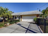 Charming single-story home with a two-car garage, well-maintained landscaping, and attractive stone accents at 1612 Sunset Dr, Tarpon Springs, FL 34689