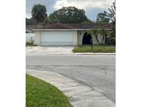 Ranch style home with a two car garage and mature landscaping at 6114 Seabreeze Dr, Port Richey, FL 34668