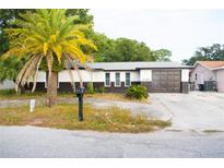 House exterior featuring a two-tone color scheme and a spacious driveway at 11300 Yellowwood Ln, Port Richey, FL 34668