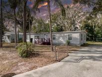 Single-wide mobile home with a small deck and fenced yard at 4110 Wedgemere Dr, Tampa, FL 33610