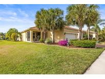 One-story house with a landscaped yard, palm trees, and a two-car garage at 4817 Sandy Glen Way, Wimauma, FL 33598