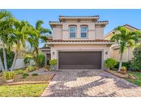 Two-story house with brown garage door, landscaping, and brick paver driveway at 4943 Grand Oak Cir, Madeira Beach, FL 33708