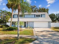 Charming two-story home with gray exterior, landscaping, and a two-car garage at 8304 Sandstone Ct, Tampa, FL 33615