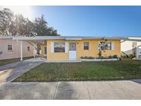 Adorable yellow house with carport and well-maintained landscaping at 5430 Palm Crest N Ct, Pinellas Park, FL 33782