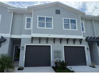 Two-story townhouse featuring attached garages and a neutral color scheme at 5725 Desert Rose Pl, Tampa, FL 33615