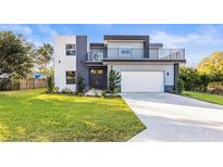 Modern two-story house with gray and white exterior, balcony, and attached garage at 6117 E 113Th Ave, Temple Terrace, FL 33617