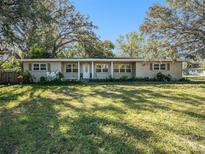 Tan single story home with large yard and mature trees at 1601 Lakeview Rd, Clearwater, FL 33756