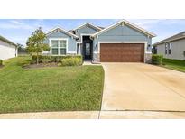 Single-story home with a brown garage door and well-manicured lawn at 34251 Radley Way, Wesley Chapel, FL 33545