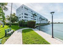 Waterfront building with walkway, landscaping, and canal views at 5925 Shore S Blvd # 210, Gulfport, FL 33707