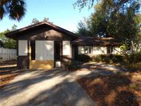 House exterior featuring a brown roof, light-colored siding, and a paved driveway at 8510 Renald Blvd, Temple Terrace, FL 33637
