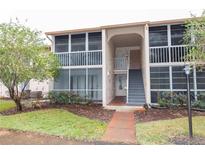Building exterior showcasing a well-maintained condo building with stairs and landscaping at 12119 Sunny Glen Ln # F1, Hudson, FL 34669