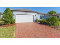 Single-story home with a brick driveway and landscaped yard at 19494 Sea Glass Cir, Land O Lakes, FL 34638