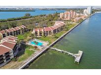 Waterfront condominium complex featuring a community pool and dock access on a sunny day at 7550 Sunshine Skyway S Ln # T48, St Petersburg, FL 33711