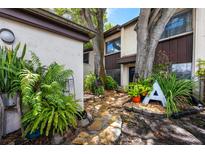 Stone walkway leads to charming condo entrance, flanked by lush greenery at 1881 N Hercules Ave # 1402, Clearwater, FL 33765