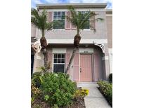 Inviting exterior of townhome with pink door and landscaping at 6232 Bayside Key Dr, Tampa, FL 33615