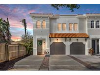 Charming townhome featuring a terra cotta roof, attached two-car garage, and welcoming front door with a wreath at 216 S Westland Ave # 4, Tampa, FL 33606