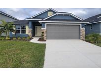 Curb appeal abounds in this charming new construction home, featuring a two-car garage and tasteful landscaping at 36179 Welsh Glade Rd, Dade City, FL 33525