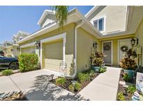 Attractive townhome exterior with landscaping and a two-car garage at 521 Harbor Ridge Dr, Palm Harbor, FL 34683