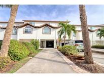 Inviting exterior of two-story townhome with attached garage and landscaped grounds at 273 Madeira Cir, Tierra Verde, FL 33715