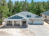 Stunning single-Gathering home boasting a three-car garage and charming front porch with stone pillars at 5062 Elm Leaf Dr, Brooksville, FL 34601